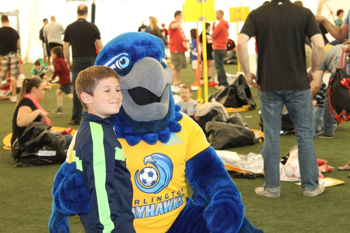 Burli hugs a child, burlington Bayhawks custom mascot costume