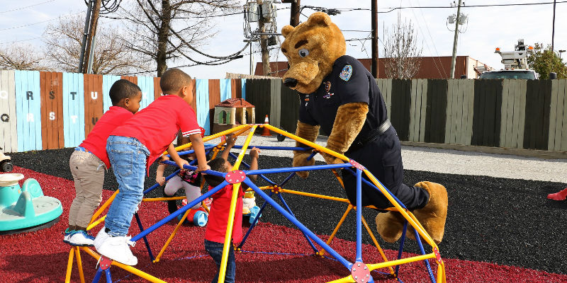 Barran's Bear mascot playing on climbing frame with children