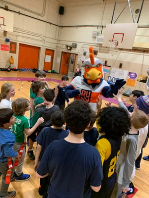 Rugby United New York Rooster with a group of children