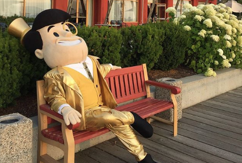 The Capitalist mascot sitting on a bench
